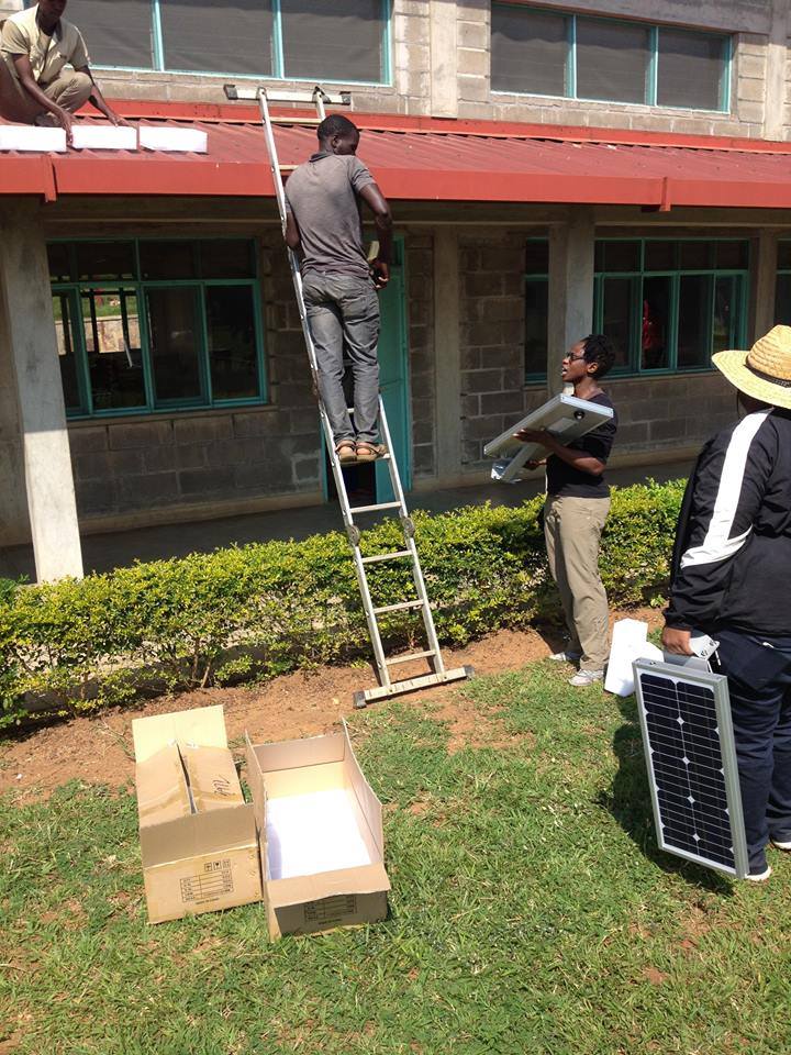 A student is on a ladder next to a building