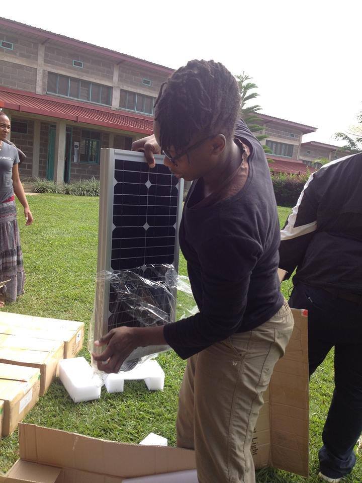A student unpacks a solar panel from plastic wrap
