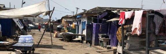 This informal settlement in Accra, Ghana lacks basic infrastructure of which electricity is one element. The electrical lines seen in the background of the photo are the fragile and irregularly placed. (Source: Eugénie L. Birch)