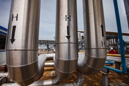 Oil refinery and gas processing plant in desert. Hydrogen sign. Technological tubes and pipelines. Close-up.