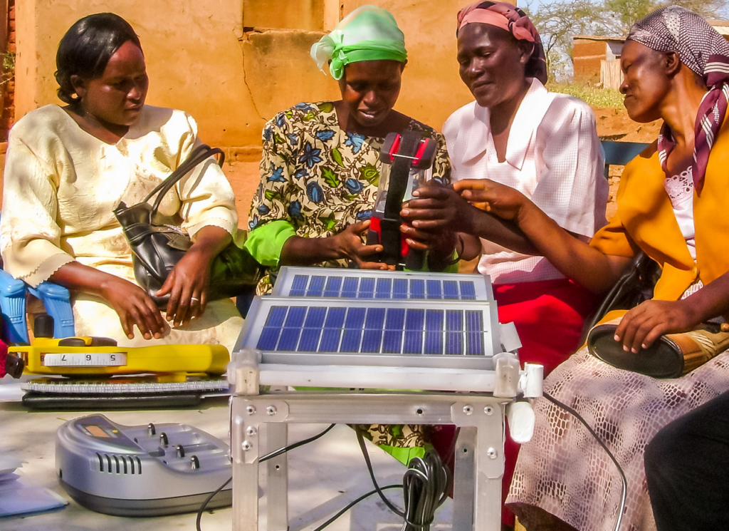 Women are huddled around a solar panel