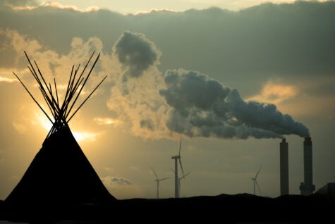 First nation sacred grounds violated by industry and technology- showing wind turbines and industrial smoke.