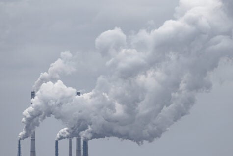 Several chimneys of a coal power station release big clouds of smoke into the atmosphere, causing heavy industrial air and environmental contamination